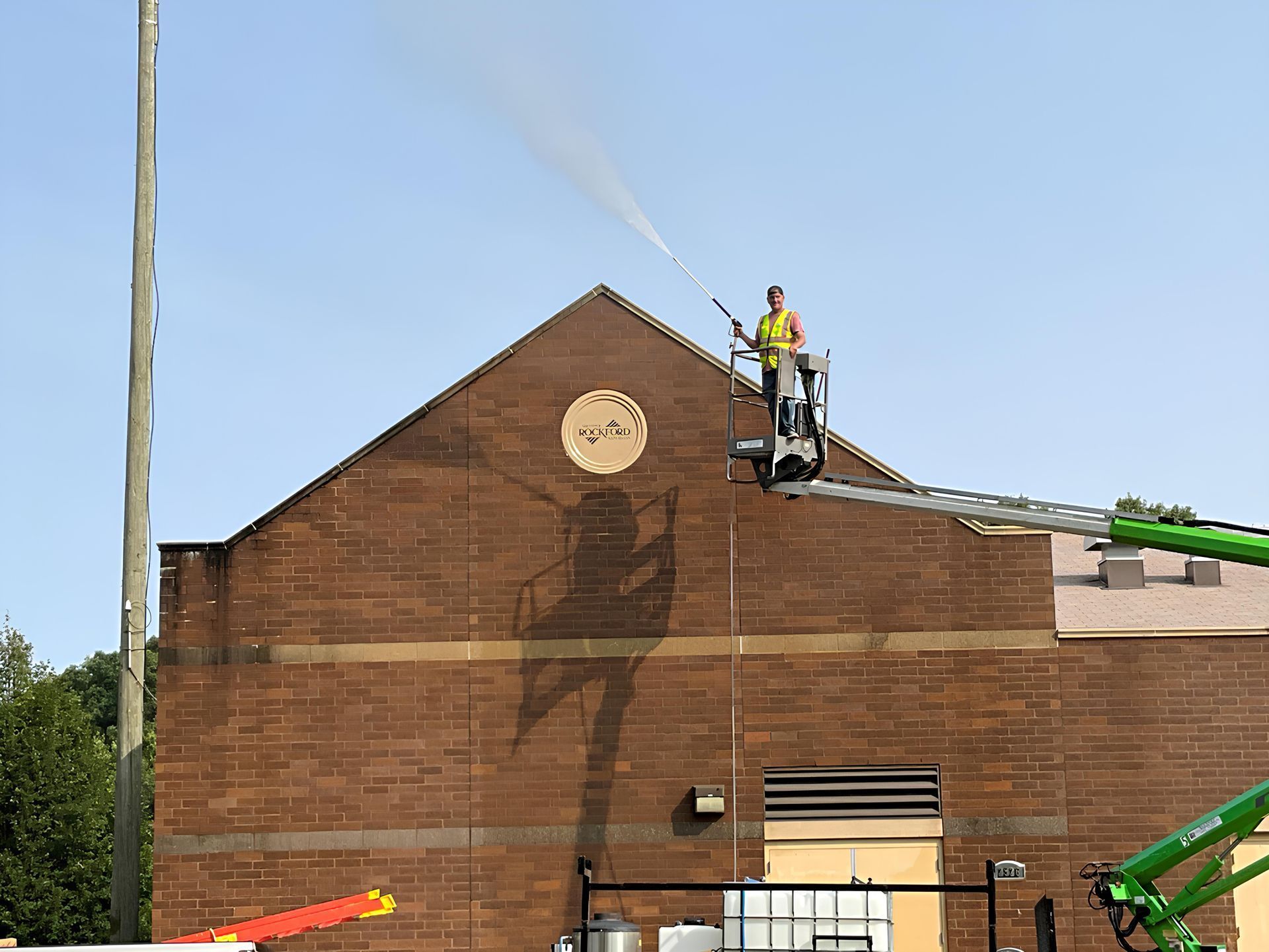 A man is spraying water on the side of a building