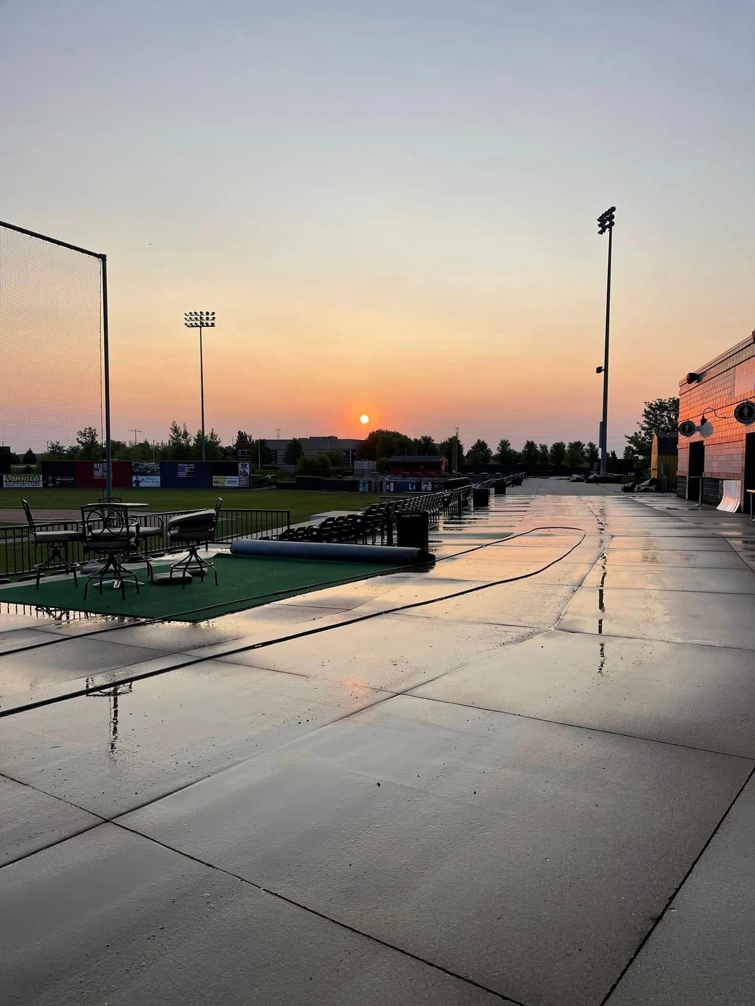 A baseball field with a sunset in the background