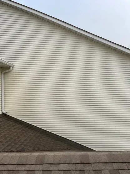 A white house with a slanted roof and a white siding.