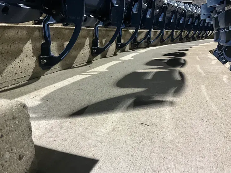 A row of stadium seats with a shadow of a person on the ground
