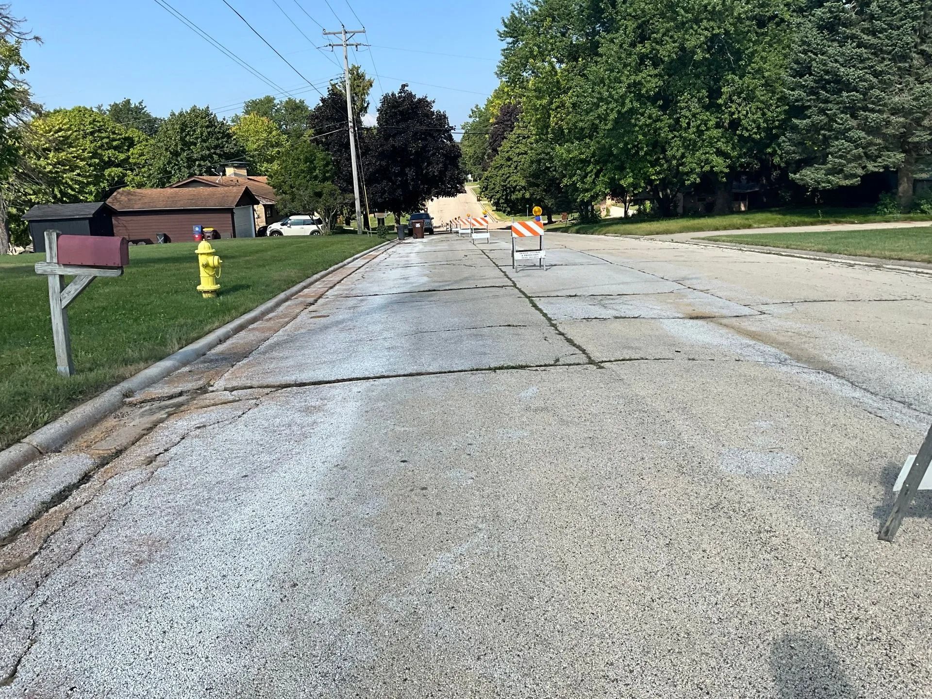 A fire hydrant is on the side of the road next to a mailbox.