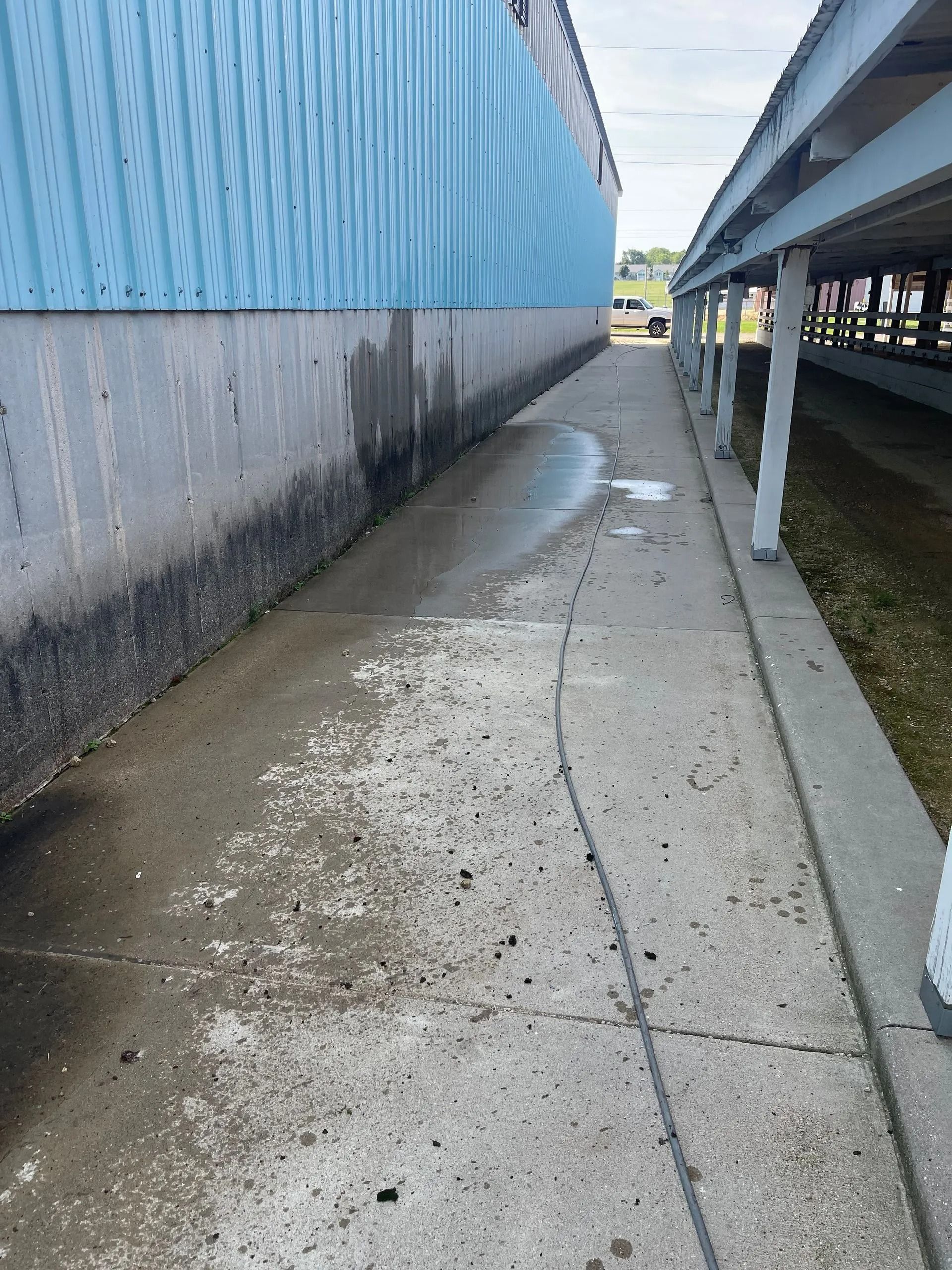 A concrete walkway with a blue building in the background