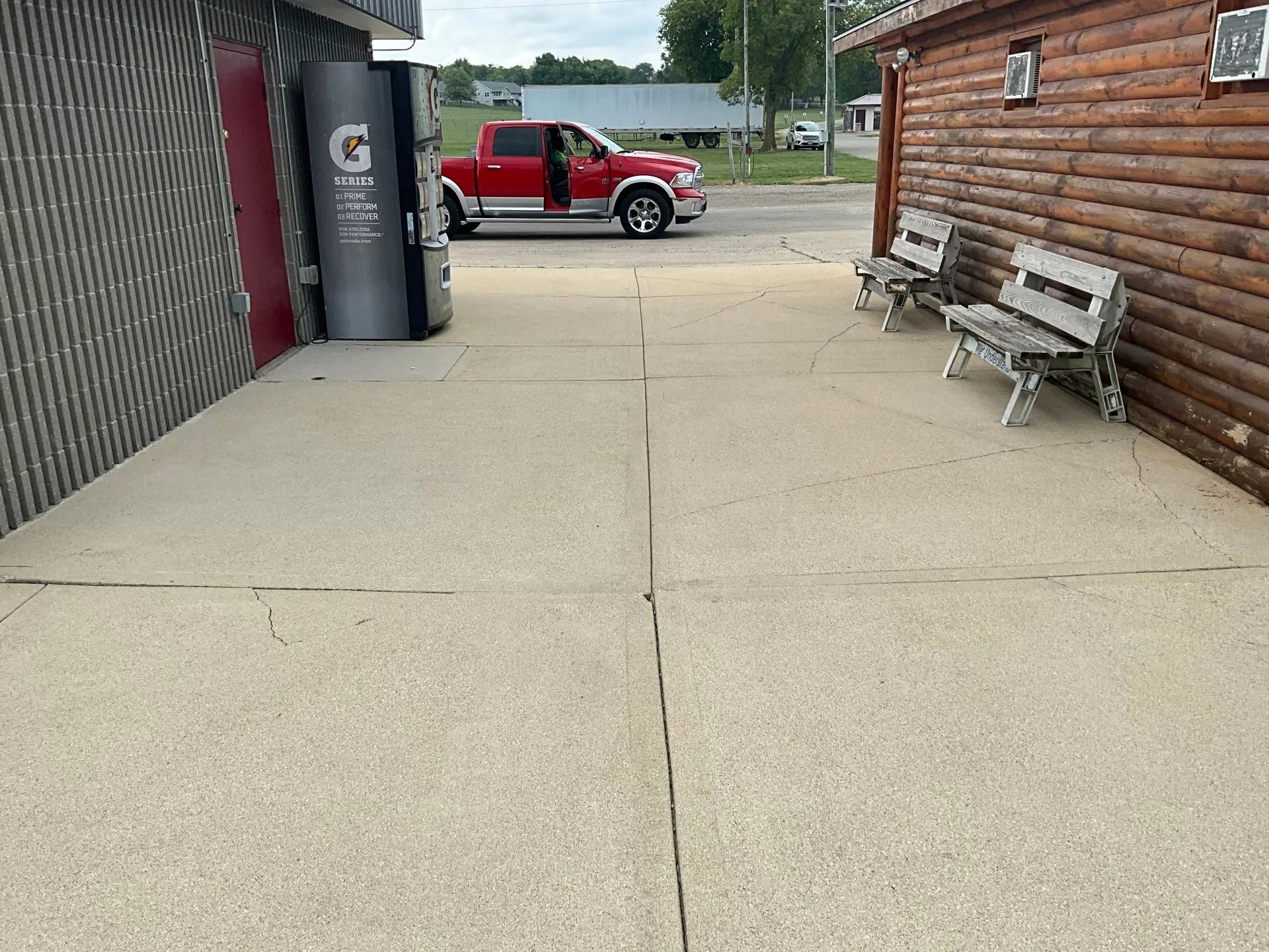 A red truck is parked in front of a gatorade machine.