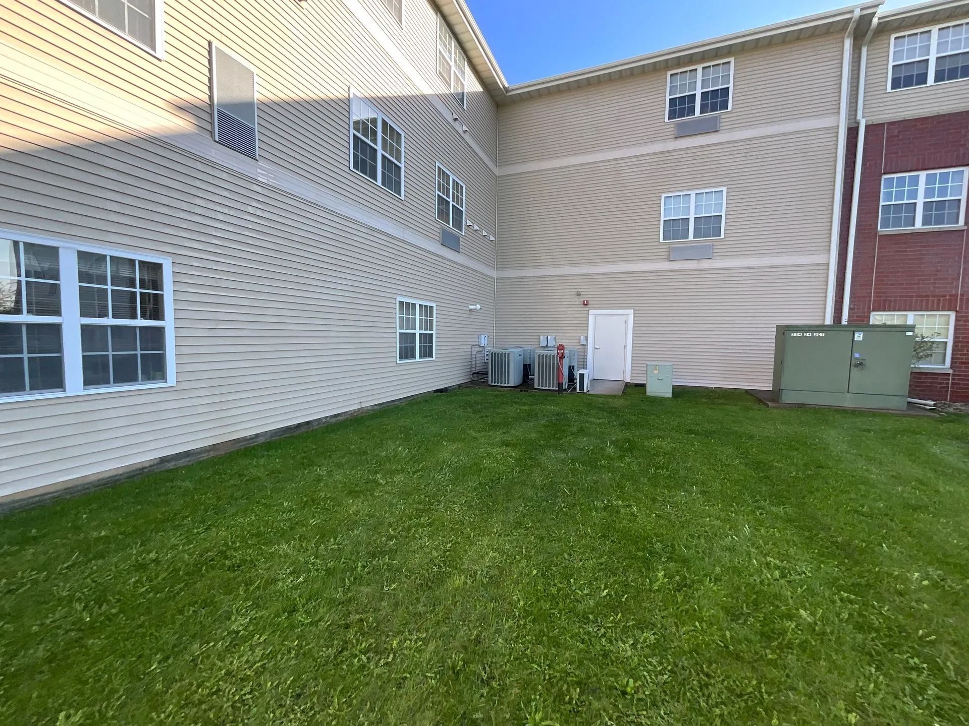 A large building with a lush green lawn in front of it.