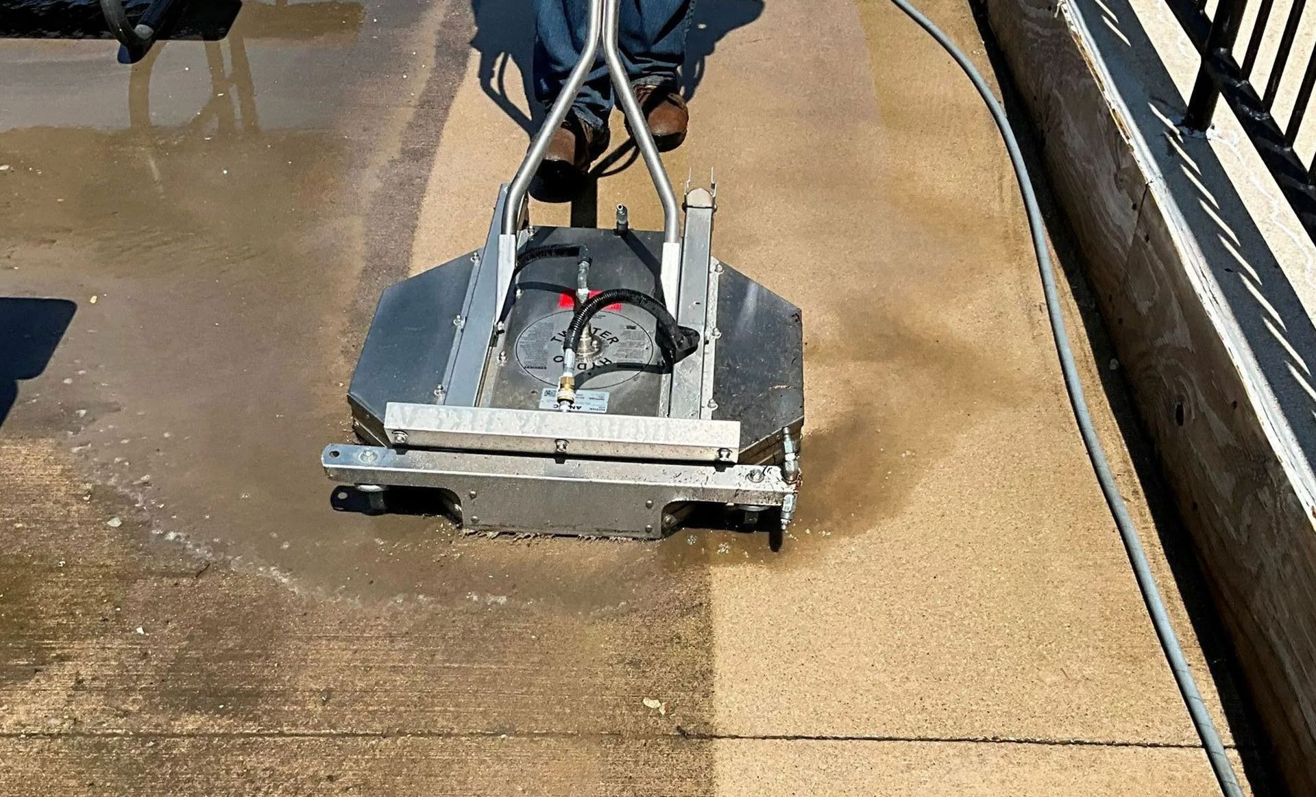 A person is using a machine to clean a concrete floor.