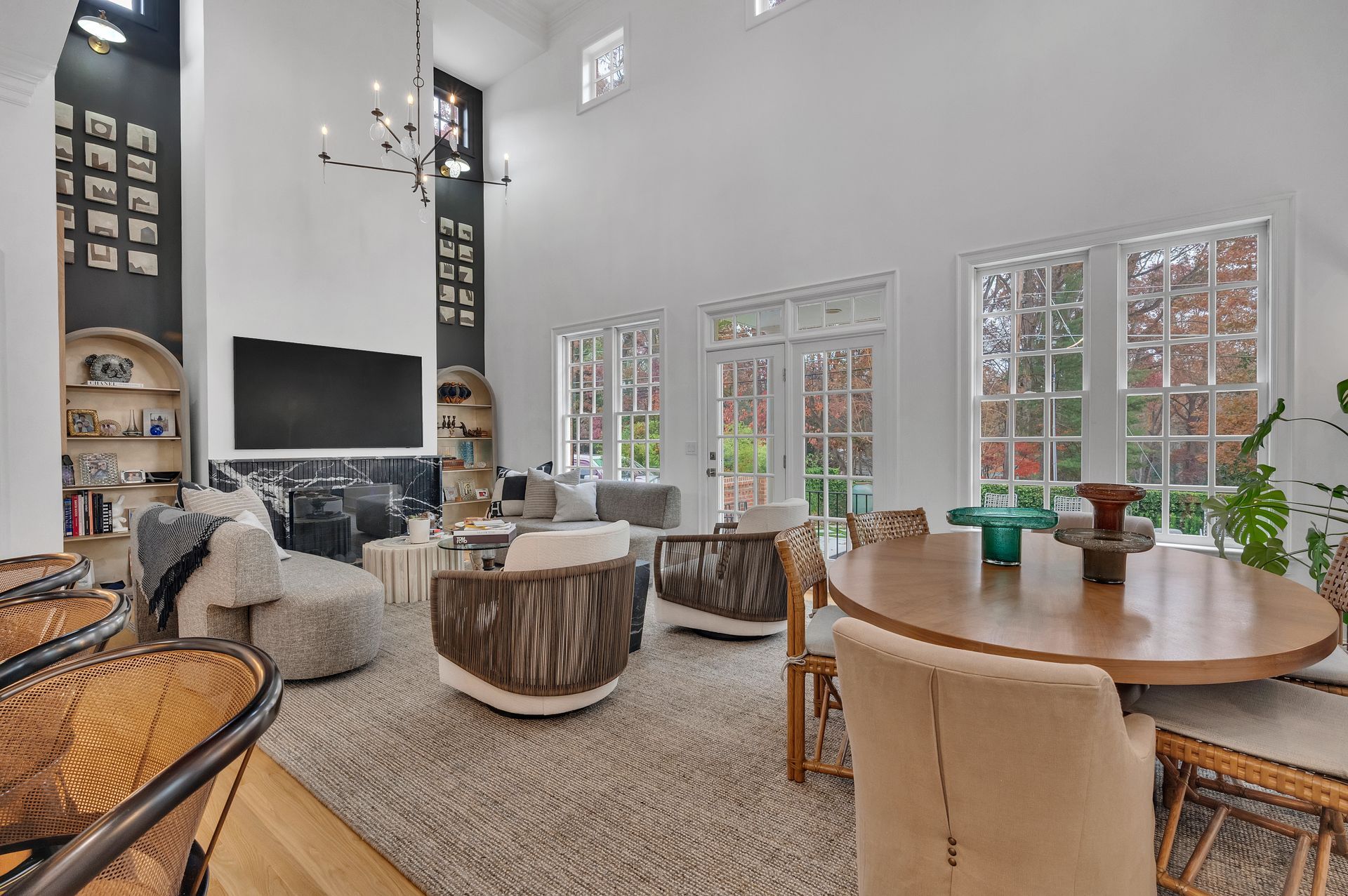 Spacious living room with high ceilings, large windows, and modern furniture.