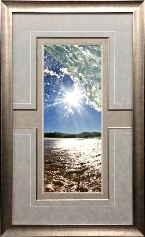 A picture of a beach with the sun shining through the clouds