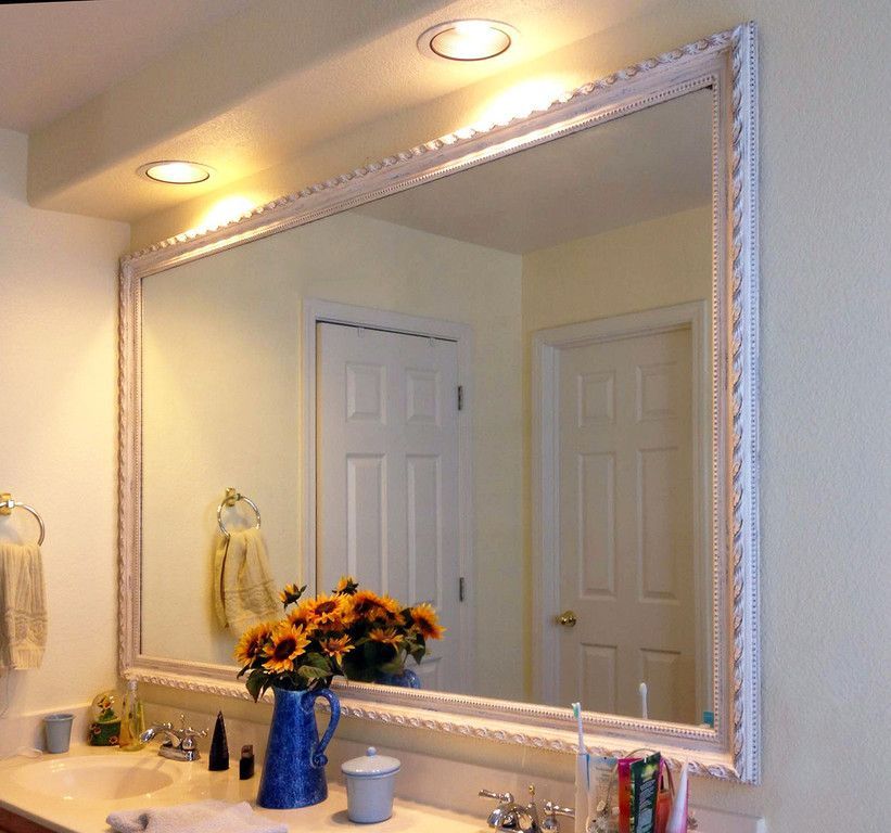 A bathroom with a large mirror and a sink