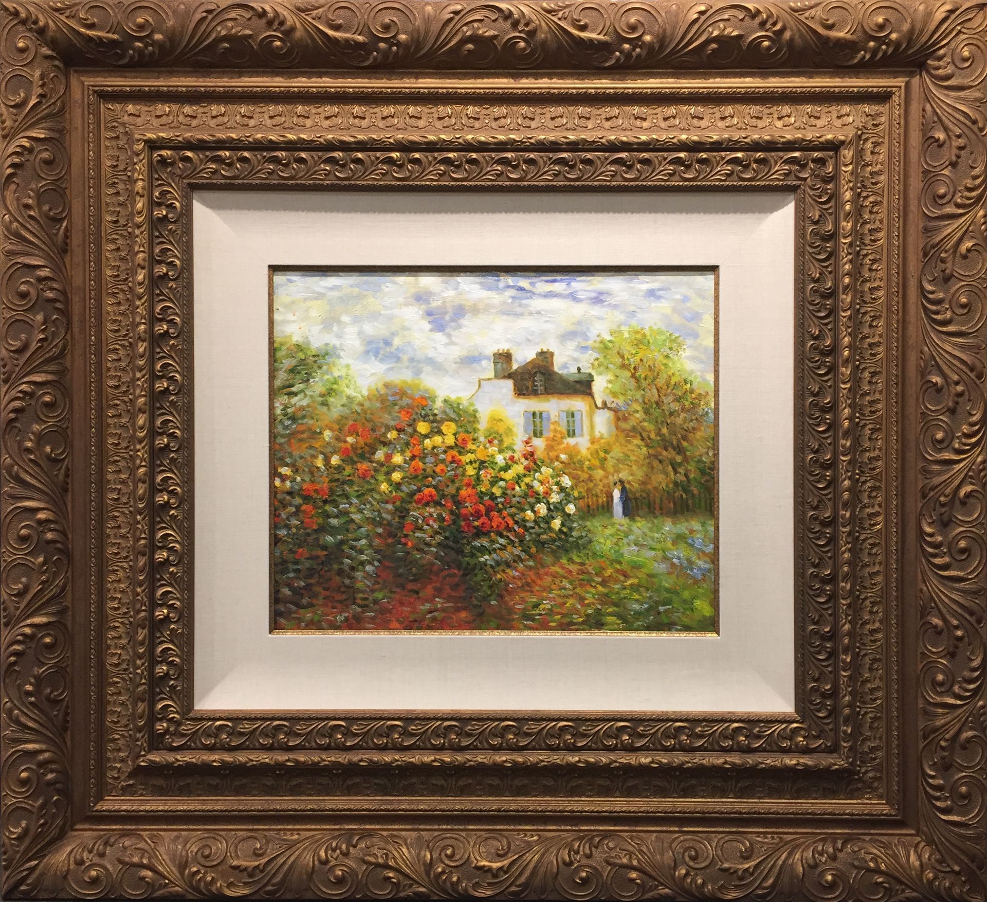 A framed painting of a house surrounded by flowers