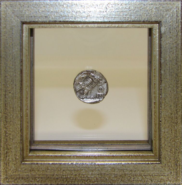 A coin in a silver frame with the number 10 on it