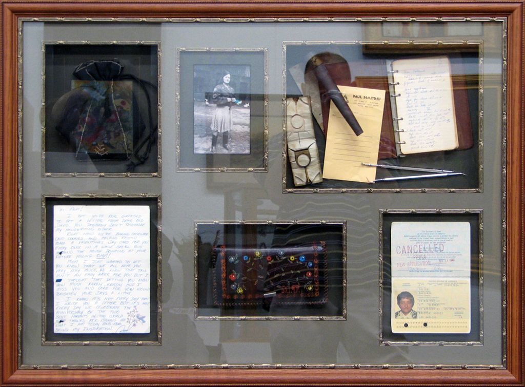 A framed display of various items including a passport