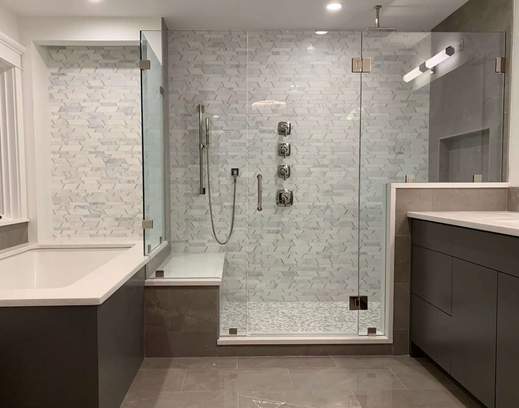 Modern bathroom with gray vanity, glass shower, and tiled walls.