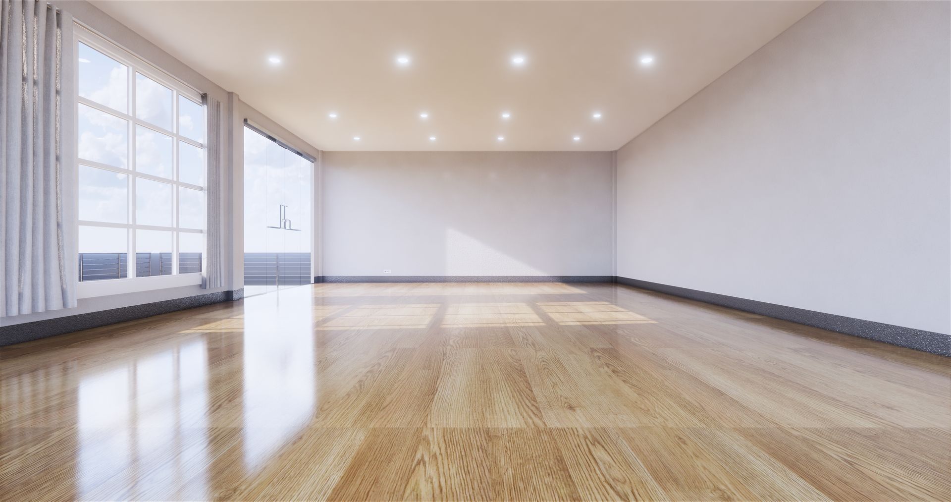 Empty room with wood floor, large windows, and recessed lighting. Sunlight streams in, illuminating the space.