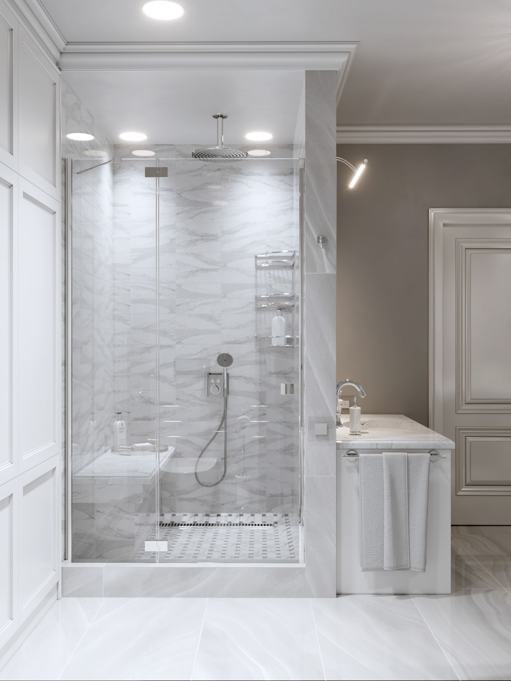 Elegant marble shower with glass door, attached bench, and adjacent vanity. Light gray and white.