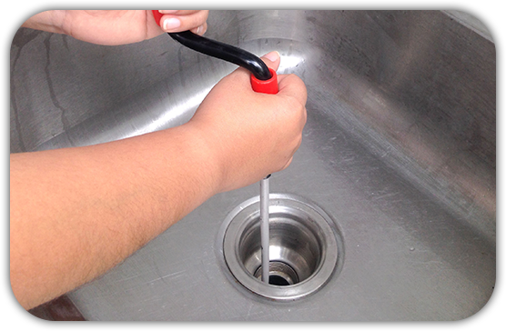 a person is cleaning a sink with a plunger