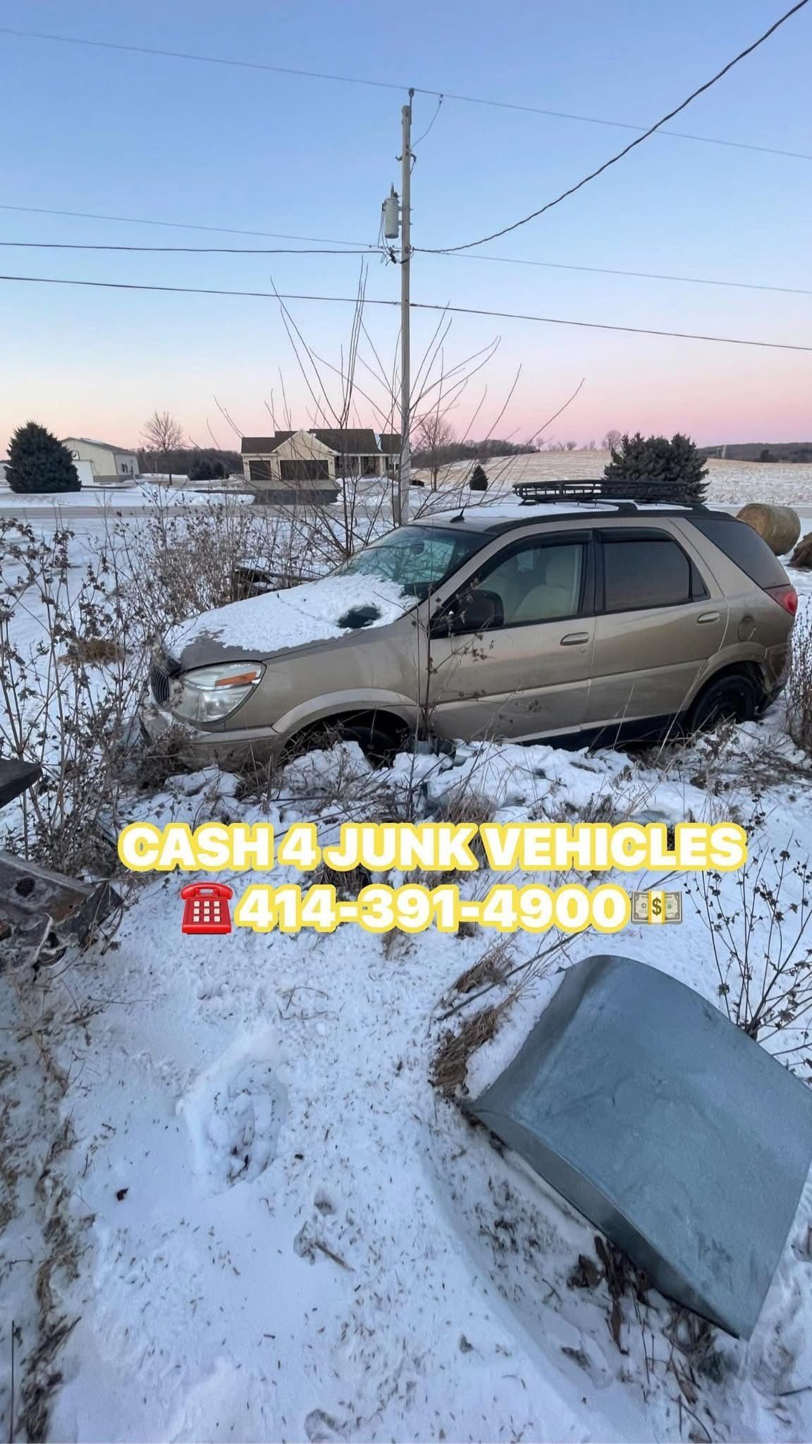 Tan SUV stuck in snowy ditch with junk vehicle ad and phone number. 