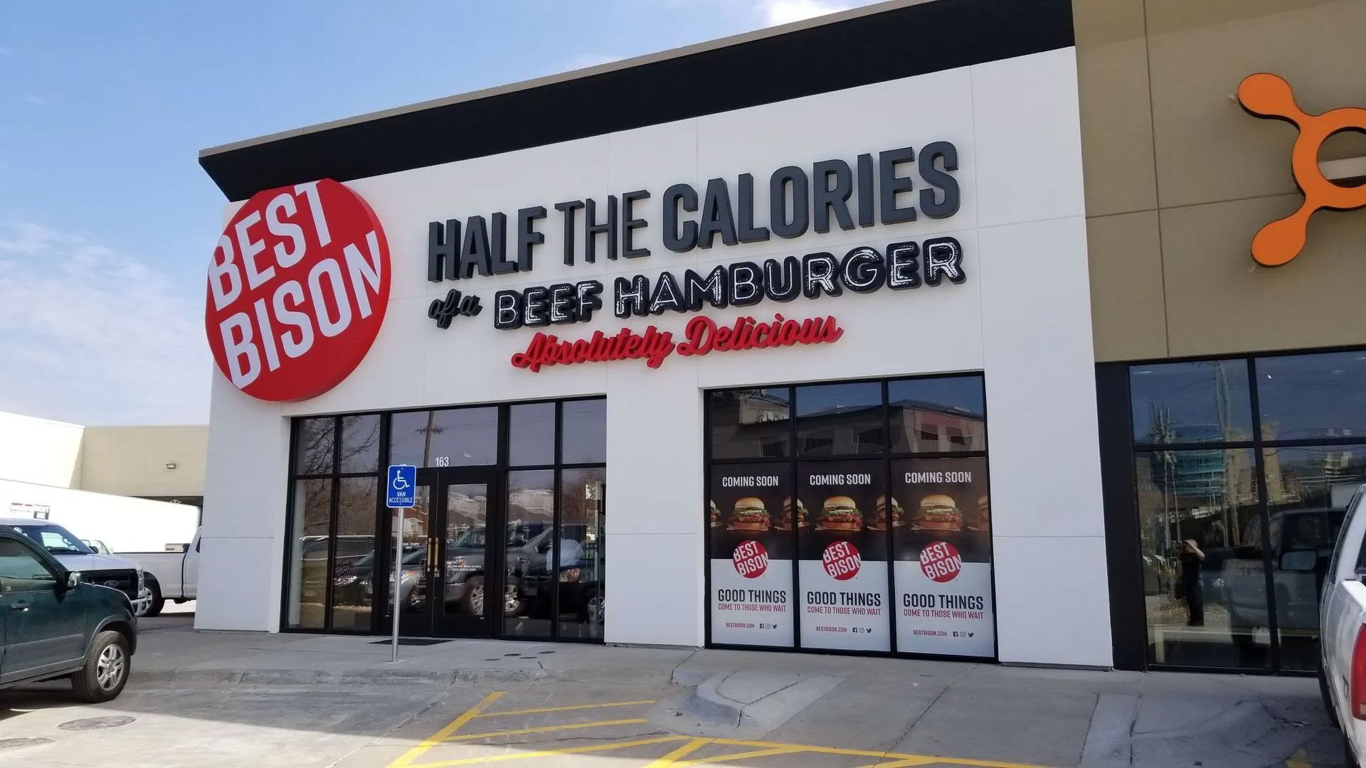 Exterior of Best Bison restaurant with black lettering and red logo, storefront with windows.