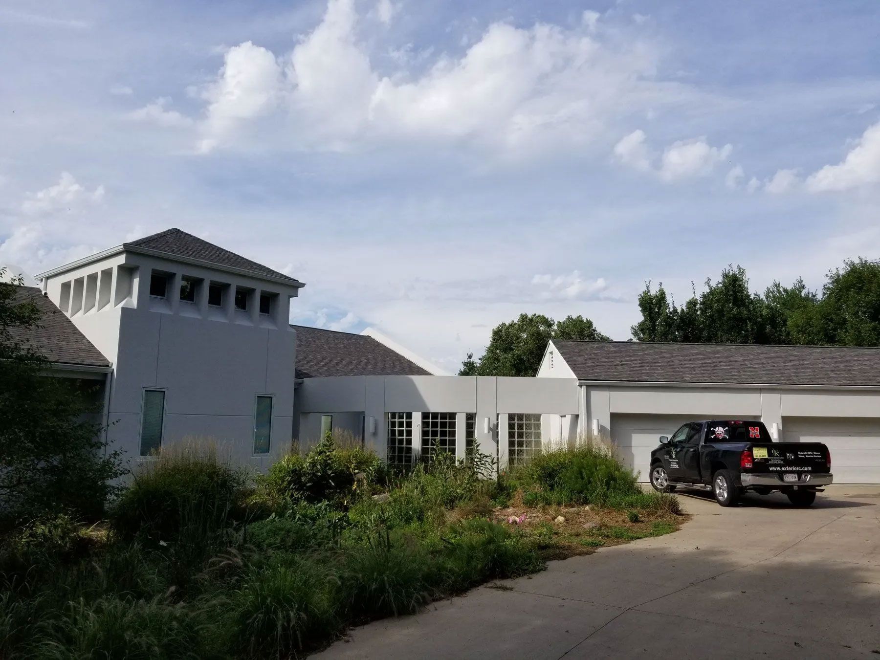 Gray house with a dark roof and a pickup truck parked in front.