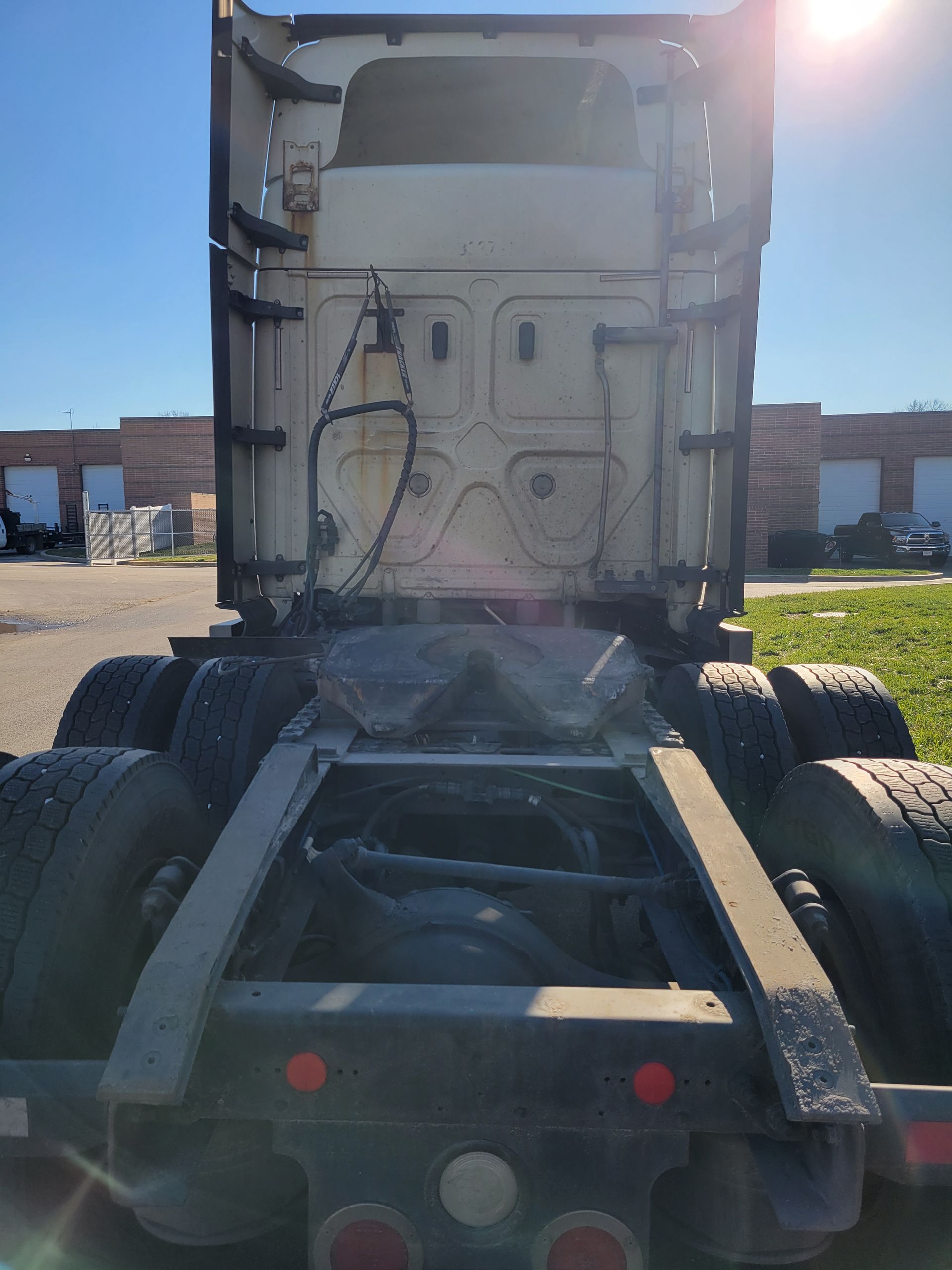A semi truck is parked in a parking lot in front of a building.