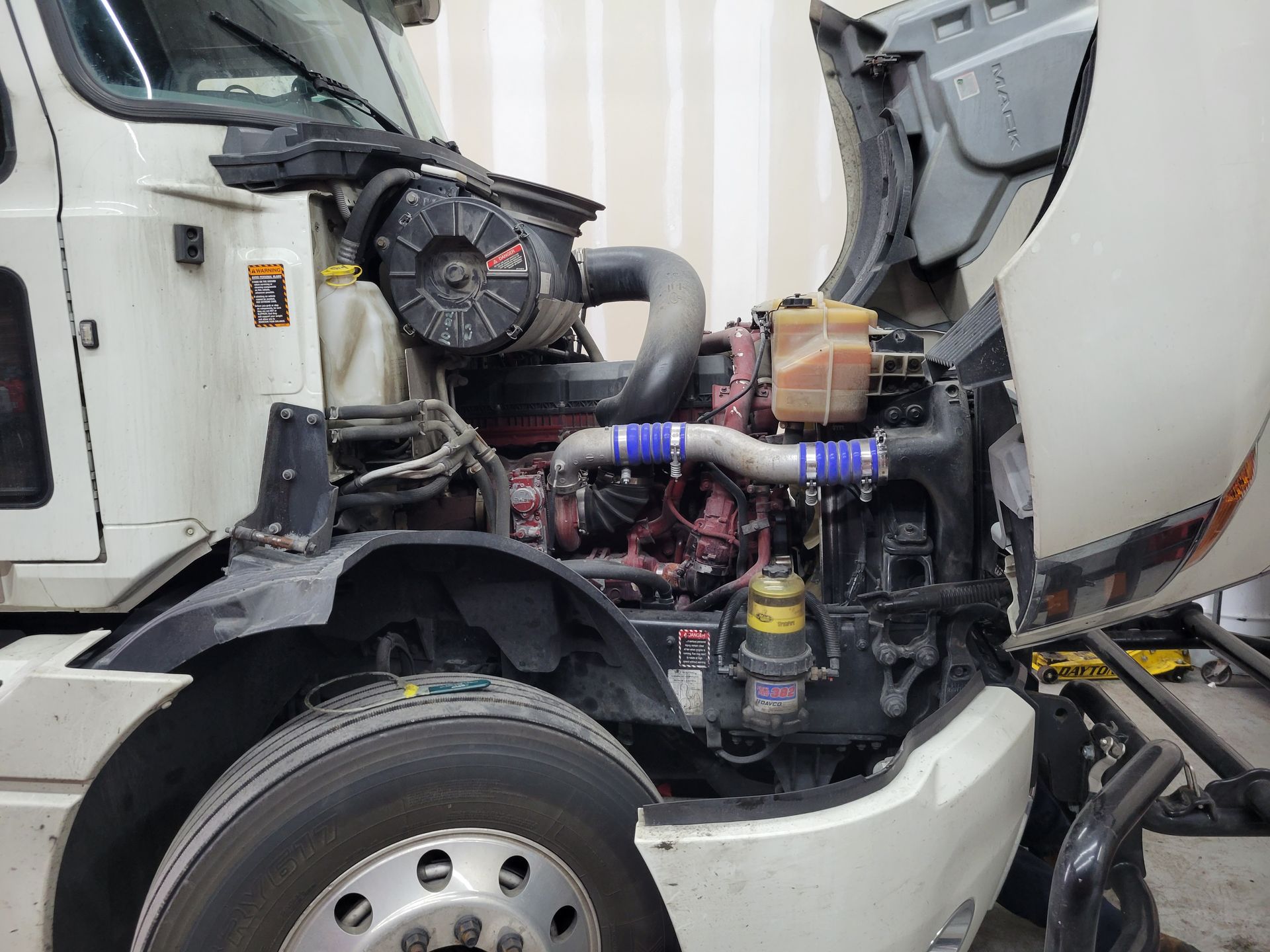 The hood of a truck is open and the engine is visible.