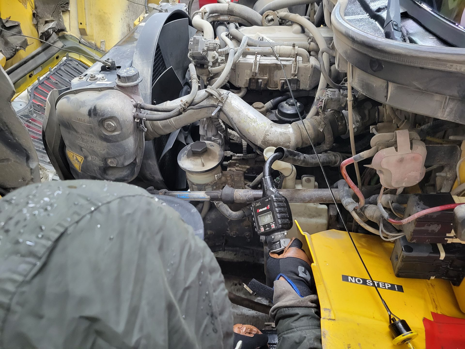 A man is working on the engine of a truck.