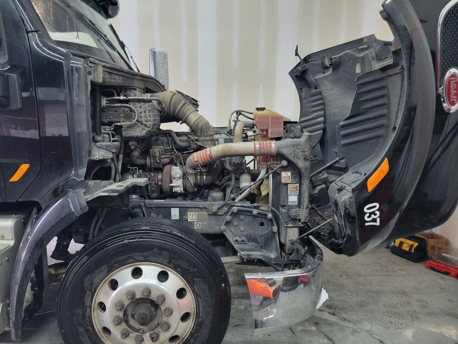 The hood of a truck is open and the engine is visible.