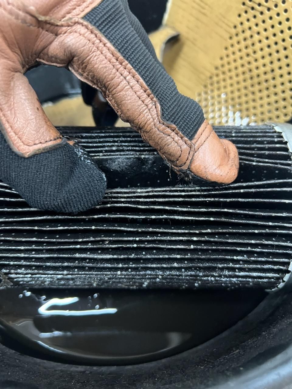 A person wearing gloves is touching a piece of black paper