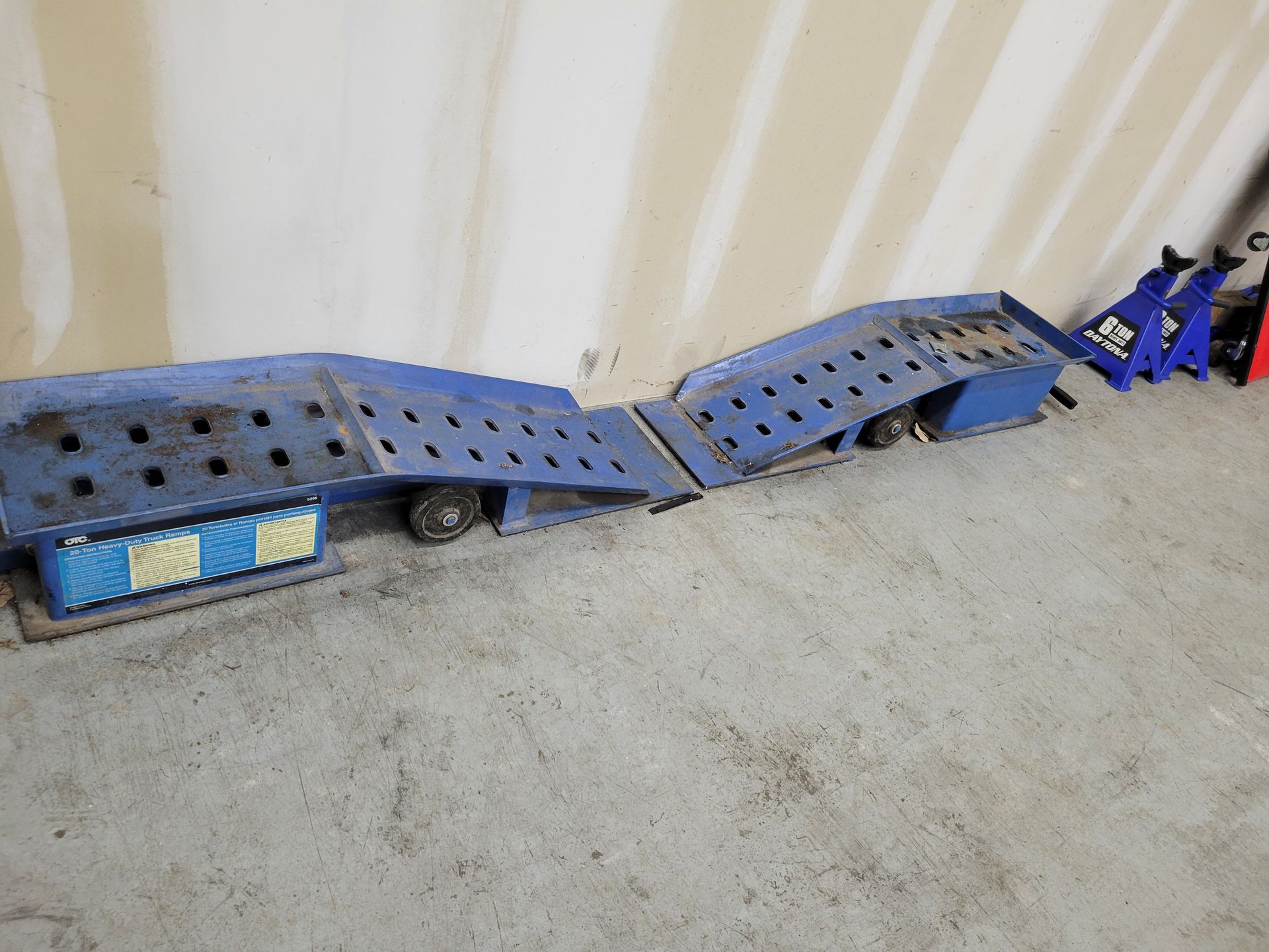 A row of blue ramps are sitting on a concrete floor