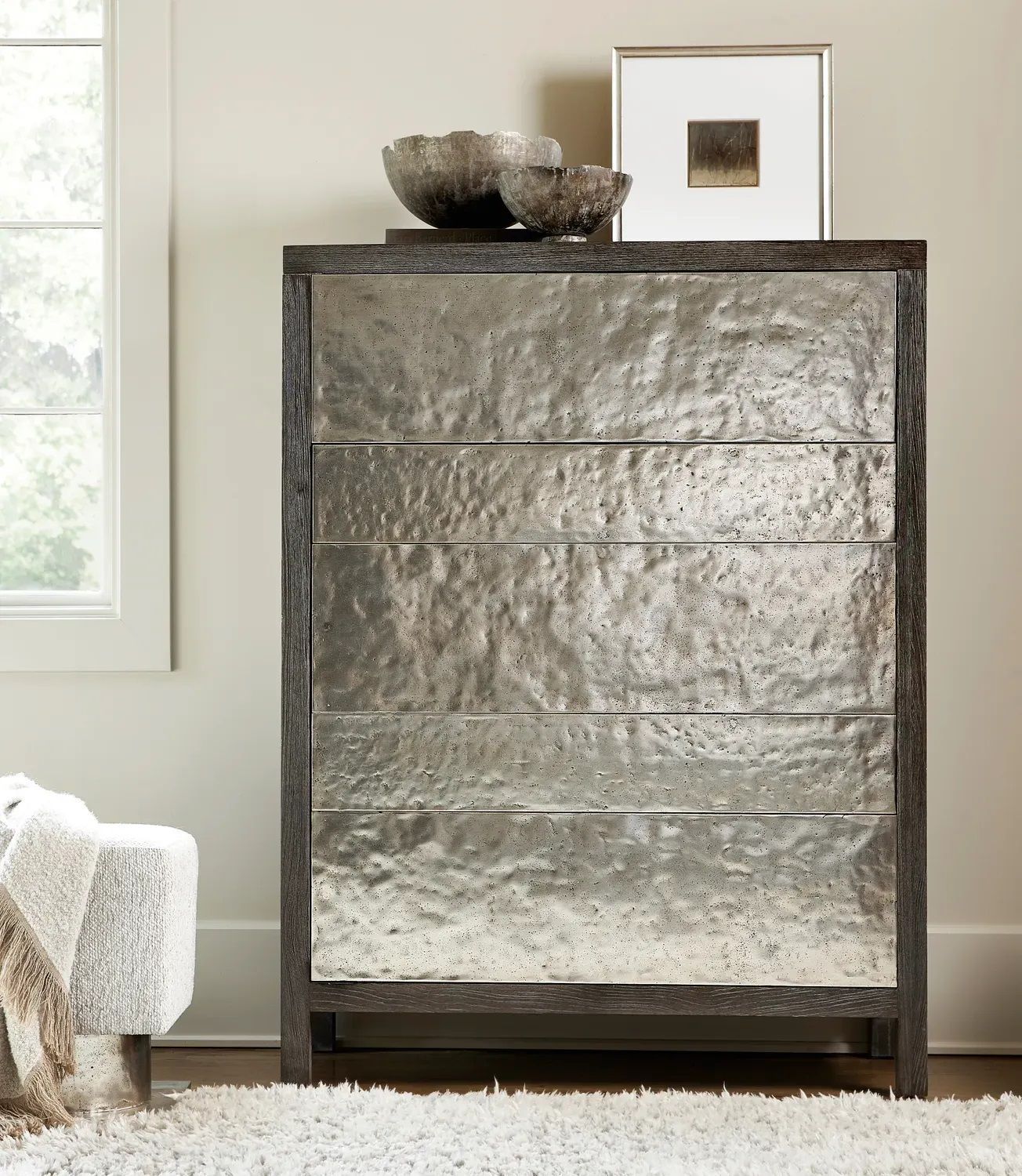 A silver chest of drawers with a picture on top of it