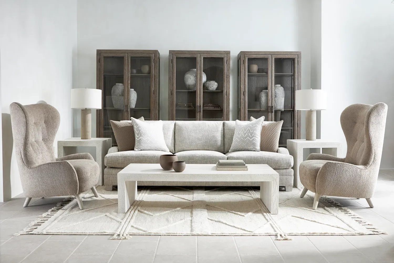 A living room with a couch, two chairs, a coffee table, and a rug.