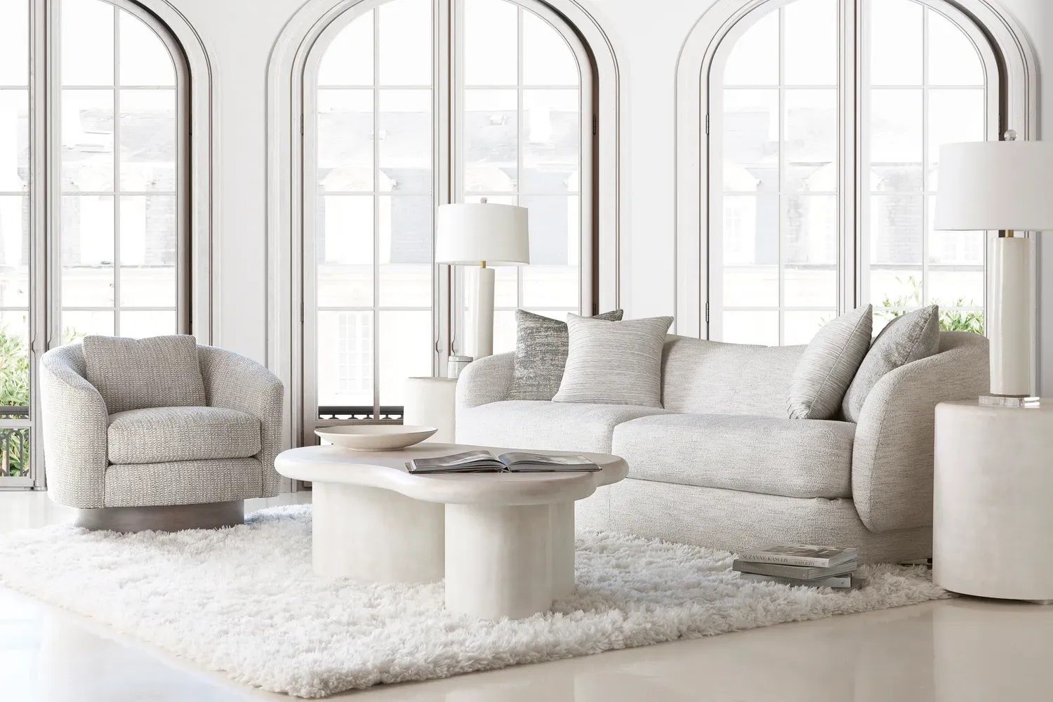 A living room with a couch, chair, coffee table, and lamps.