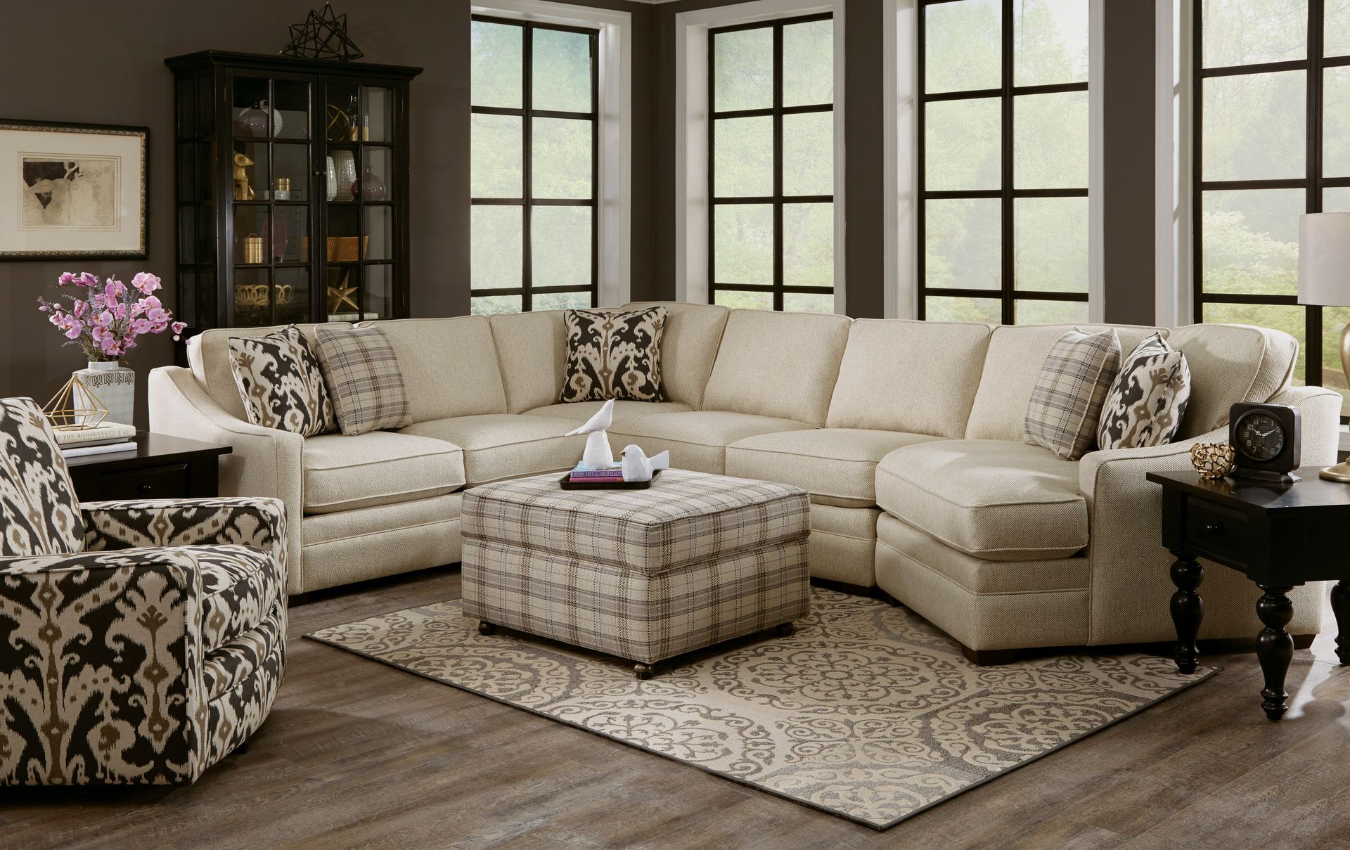 A living room with a sectional couch ottoman and chairs