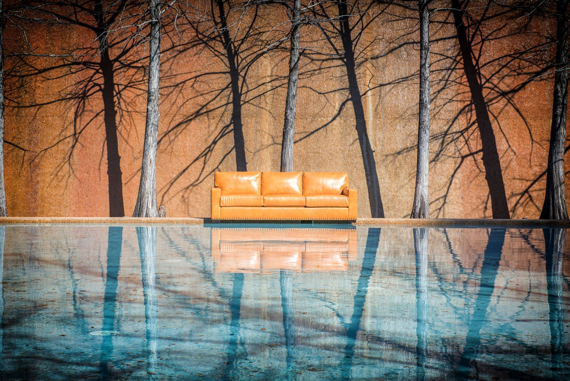 A couch is sitting in the middle of a swimming pool.