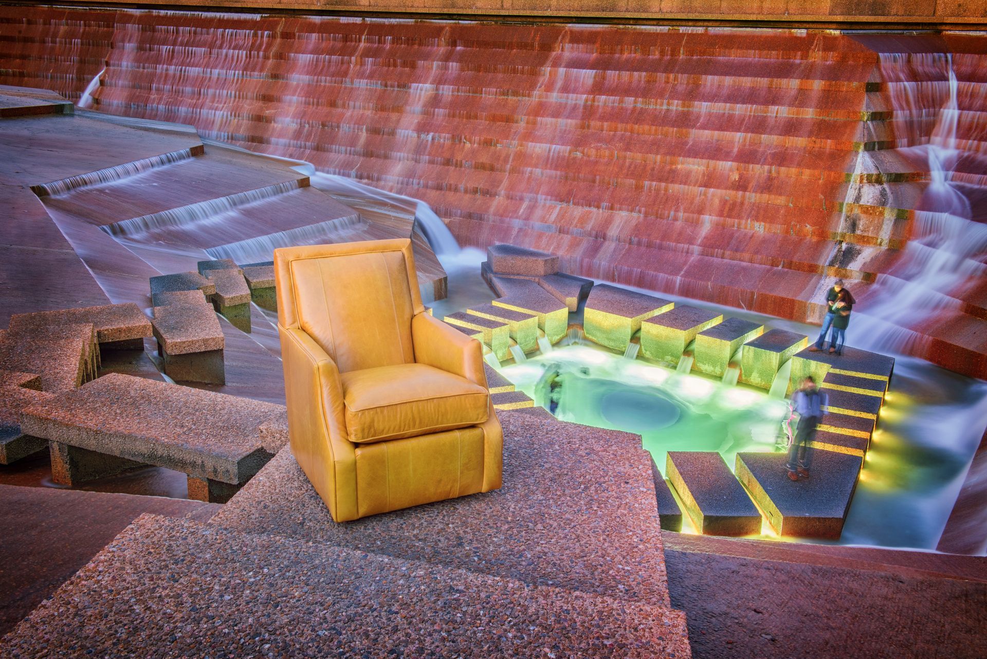 A yellow chair is sitting in front of a waterfall.
