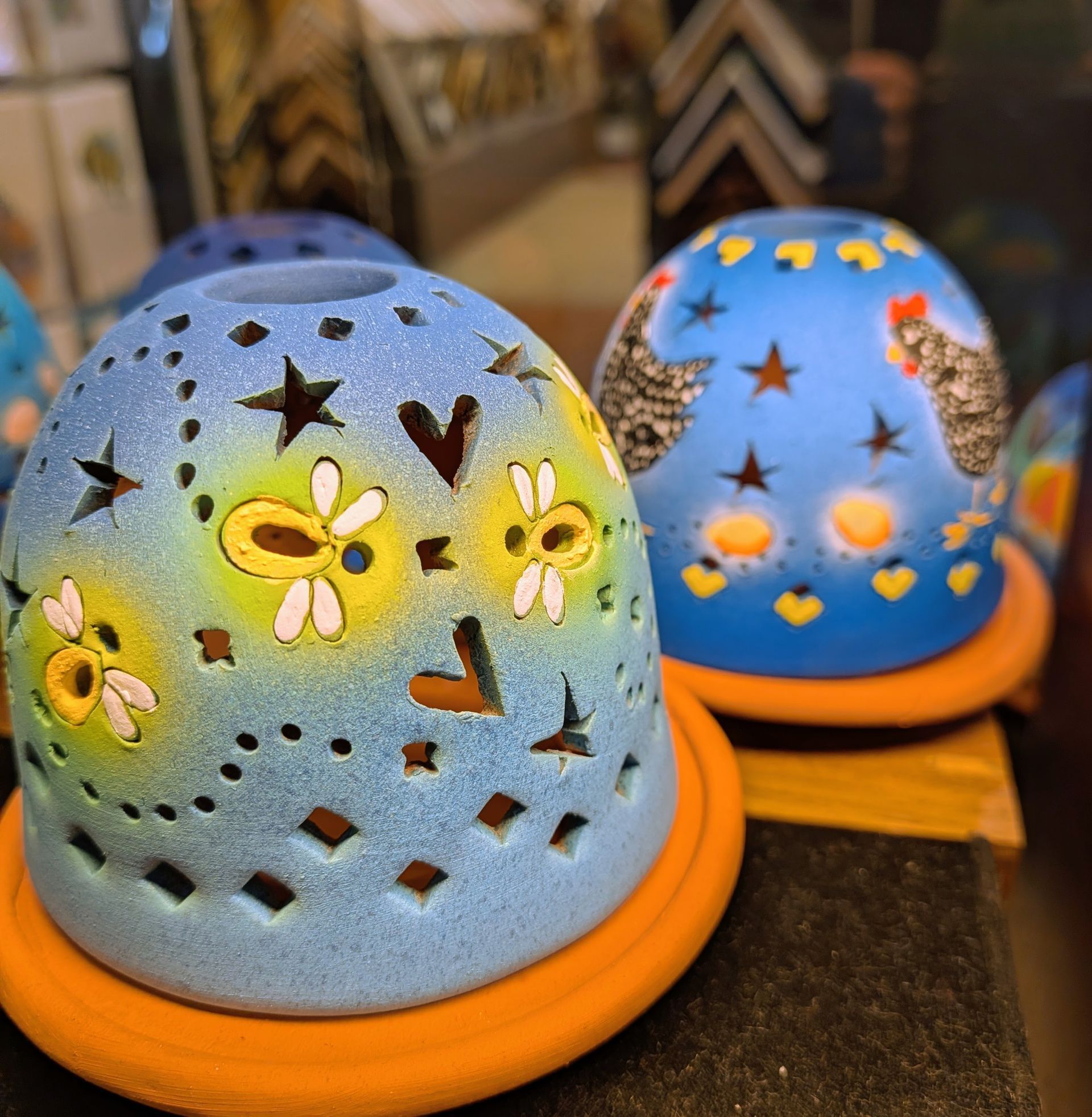 Blue floral and star-patterned ceramic candle lanterns glowing with warm orange light.