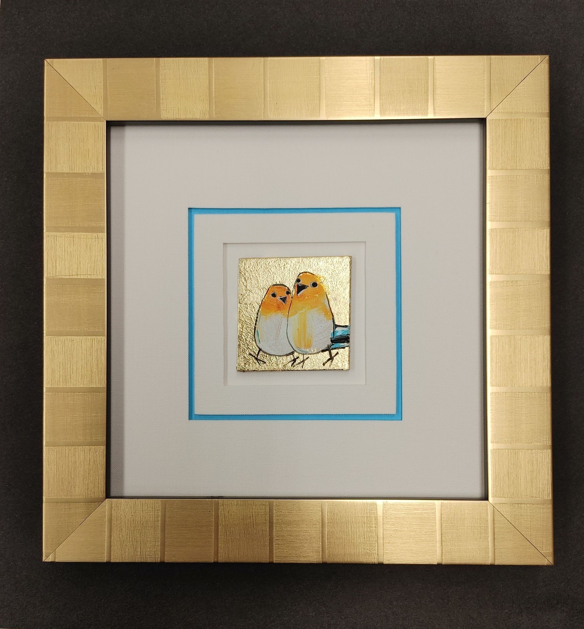 Small framed artwork centered within a larger gold frame and wide light gray mat.