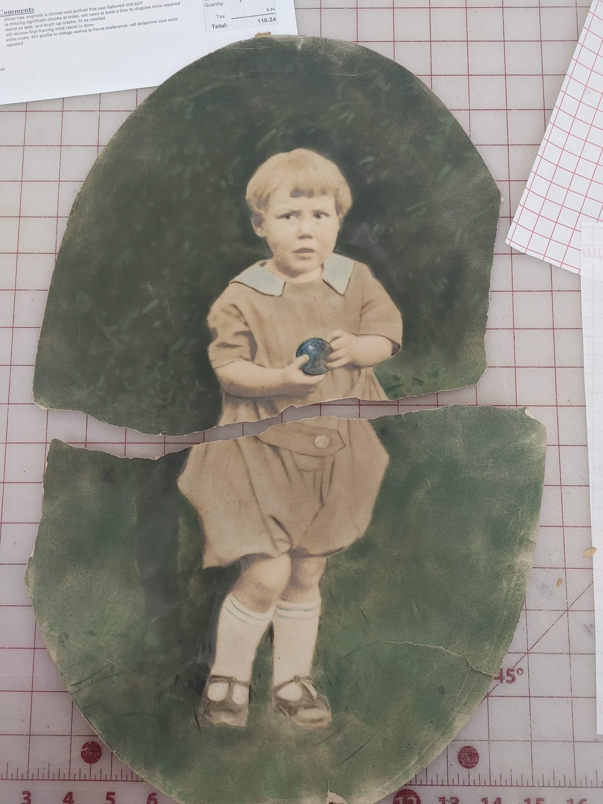 Vintage cutout of a child in tan clothes holding a blue flower against dark green oval paper.