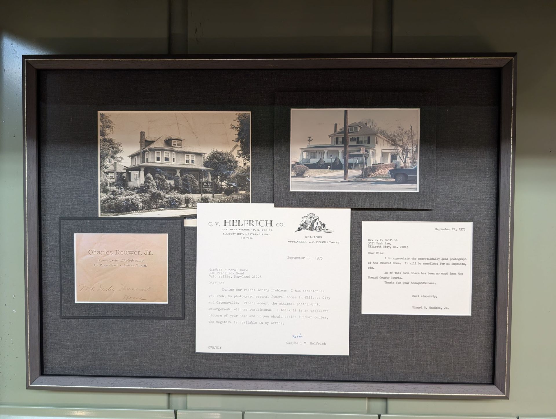 Framed display of historic house photos and documents on a dark background.