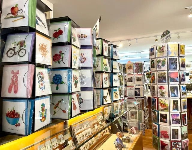Art gallery with stacked display cubes showing colorful illustrations and prints along the walls and floor shelves.