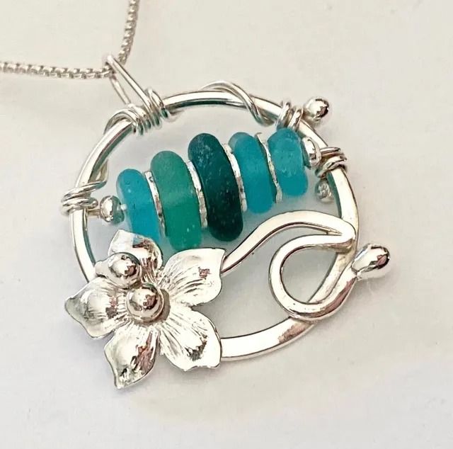 Silver pendant necklace with turquoise beads and a small flower charm