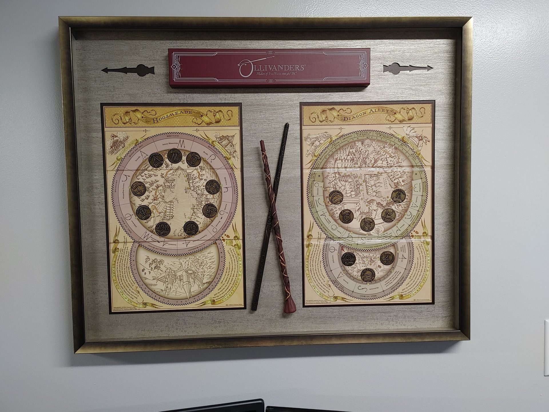 Framed collage with two vintage-style drawings and a maroon nameplate on a gray wall.