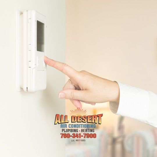 Thermostat and light switches on a white wall in an office setting.