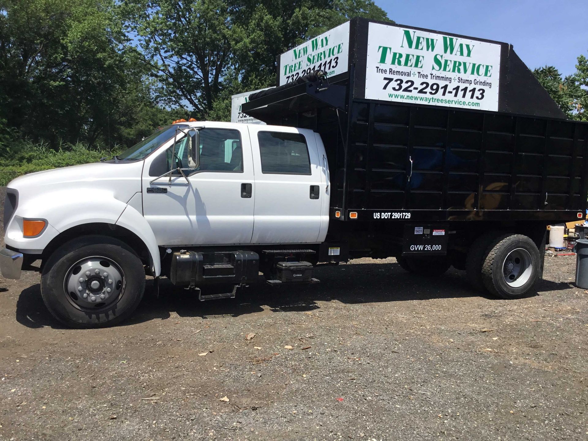 White and black New Way Tree Service truck parked outdoors.