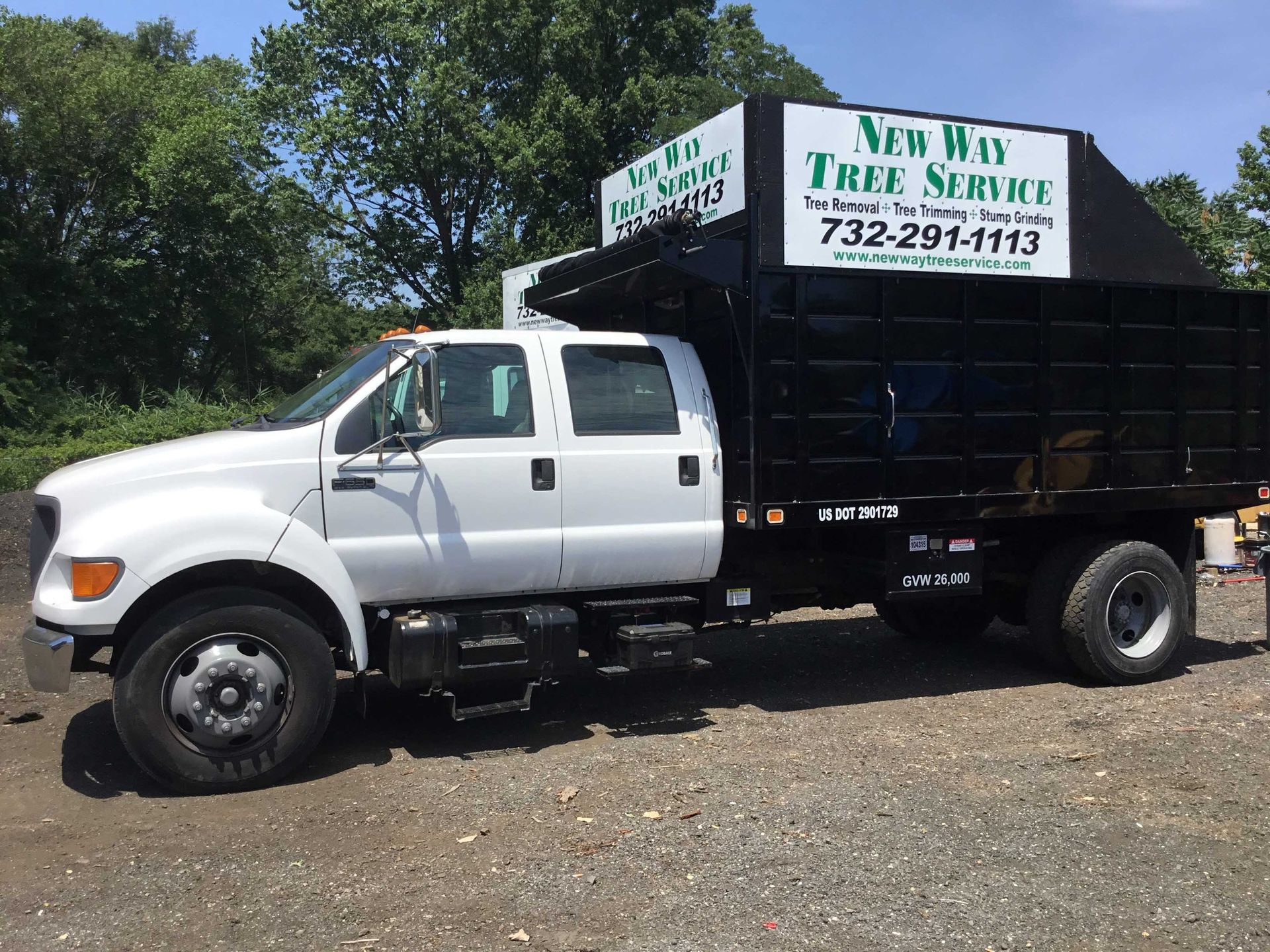 White tree service truck with black bed, text 