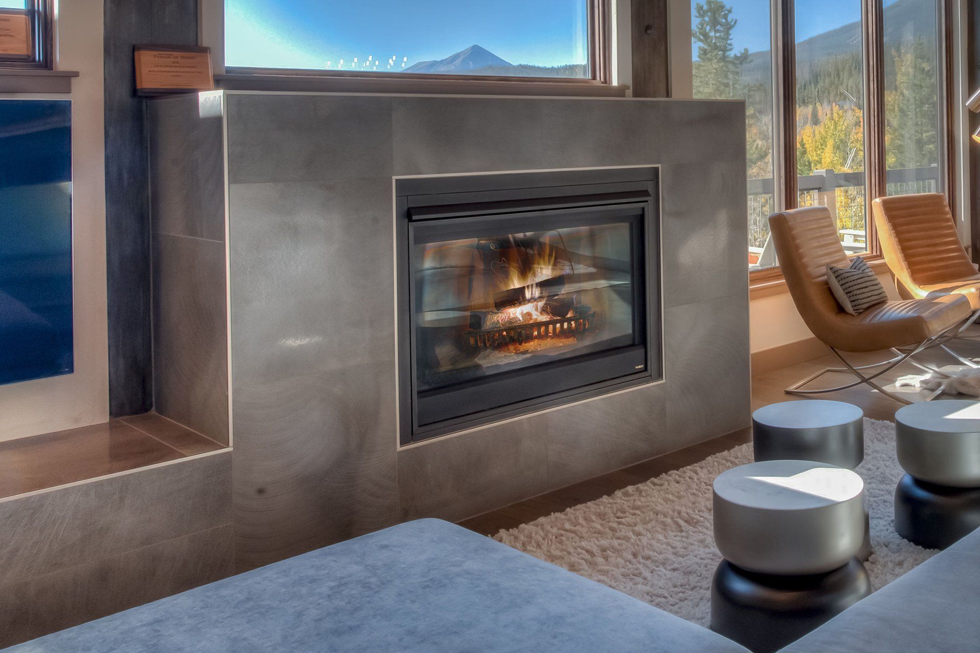 A living room with a fireplace and a large window