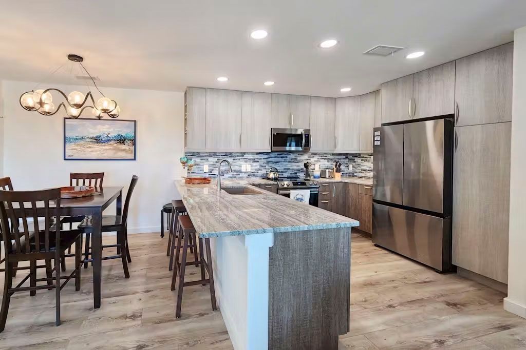 A kitchen with stainless steel appliances , granite counter tops , and a large island.