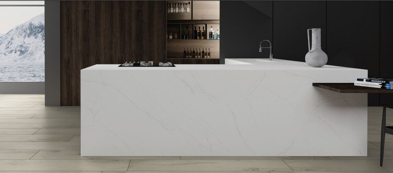 A kitchen with a large white counter top and a stove top oven.