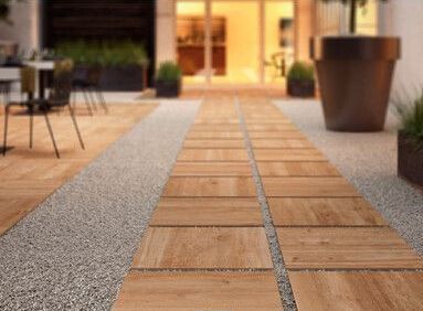 A wooden walkway leading to a building with tables and chairs.