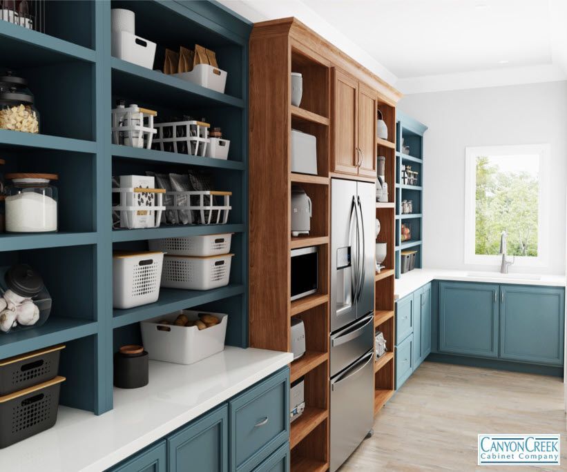 A kitchen with blue cabinets and wooden shelves and a stainless steel refrigerator.