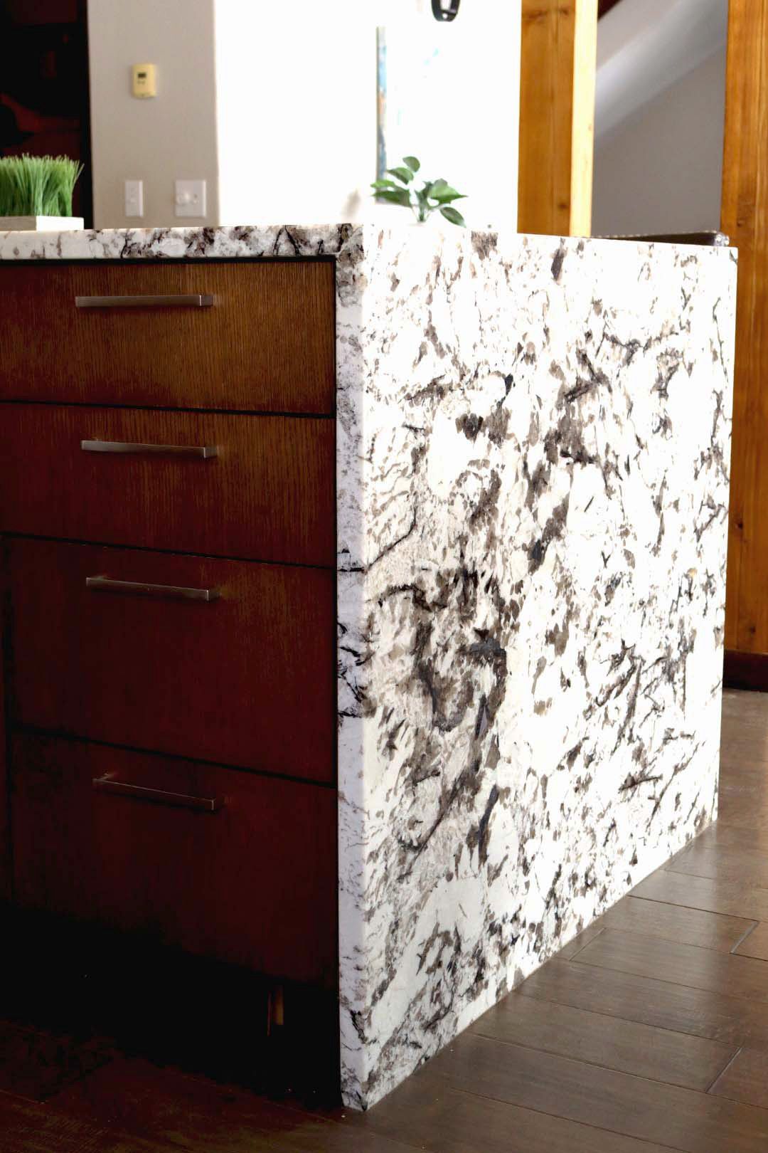 Dark wood cabinet with white marble side panel in a home interior.